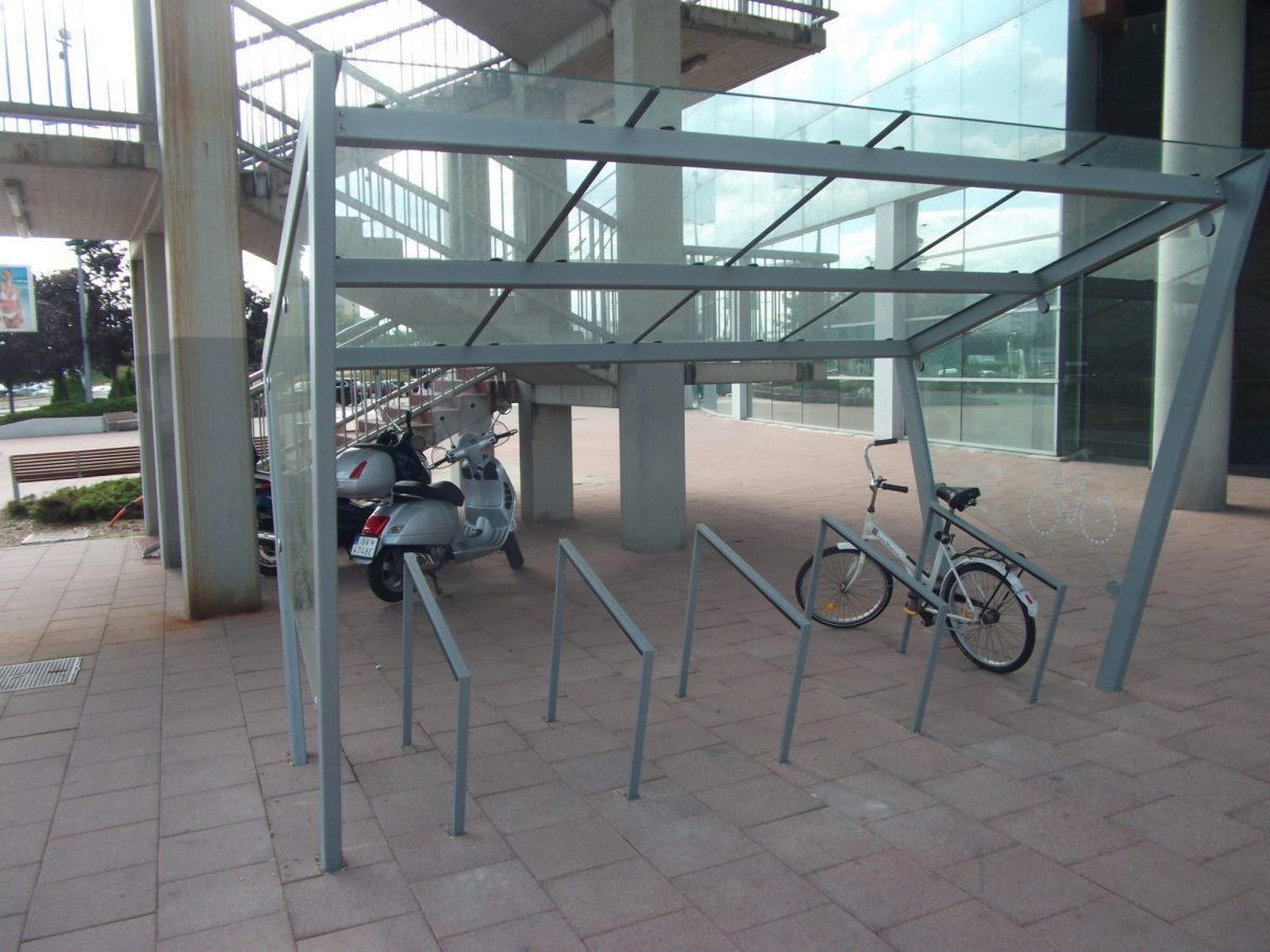Krytý stojan pre bezpečné parkovanie desiatich bicyklov pod lávkou do Auparku. Tento stojan je bohužiaľ relatívne ďaleko od vchodu do nákupného centra.